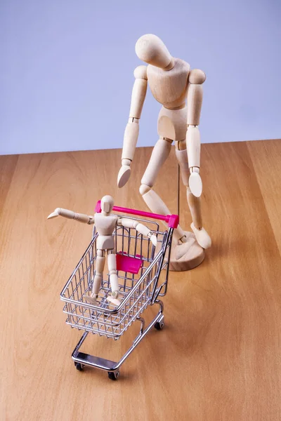 Bir alışveriş arabası ve iki insan modeli.