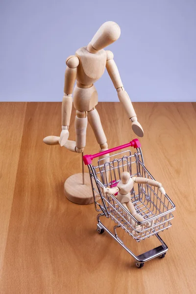 Bir alışveriş arabası ve iki insan modeli.