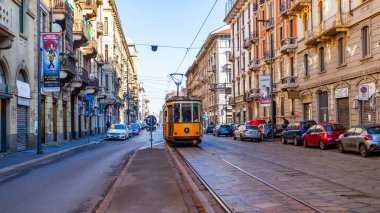 Milan, İtalya, 12 Şubat 2020. Tarihi bir binada şehrin bir caddesinde klasik bir tramvay.