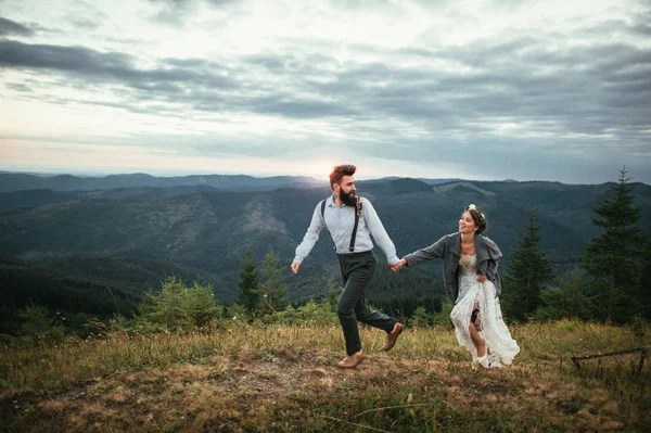 Jovem casal de mãos dadas e correndo — Fotografia de Stock