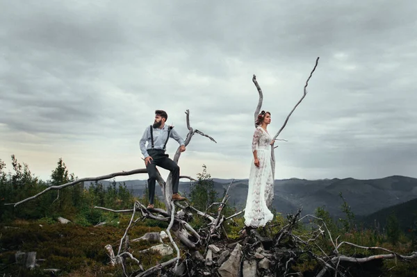 Hombre y mujer de pie sobre madera muerta — Foto de Stock