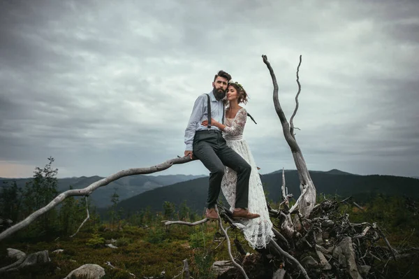 Couple étreignant et debout sur du bois mort — Photo