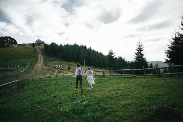 Pareja cogida de la mano y corriendo — Foto de Stock