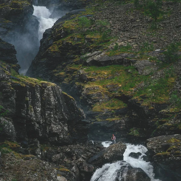 Hipster man near waterfall in mountains — Stock Photo, Image