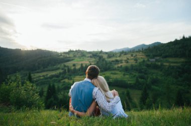 Yeşil çimenlerin üzerinde sarılma Çift