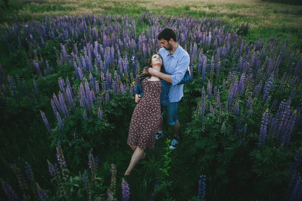 Jovem casal em flores roxas — Fotografia de Stock