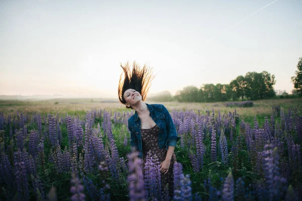 Woman having fun in purple flowers — Stock Photo, Image