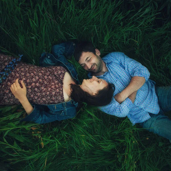 Casal deitado na grama verde — Fotografia de Stock