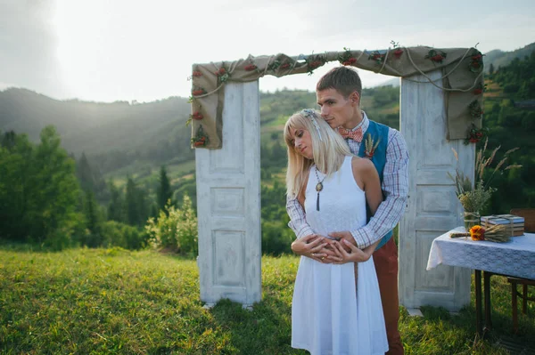 couple near wedding frame outside