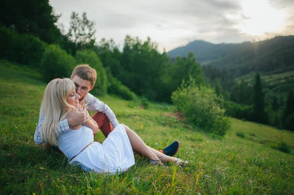 Пара обнимается на зеленой траве — стоковое фото