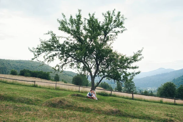 Casal sob árvore verde — Fotografia de Stock