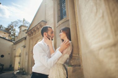 Çift duvara yakın poz kucaklayan 