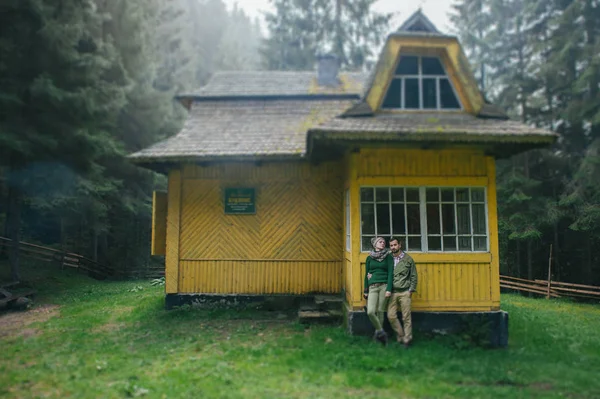 Пара позує біля жовтого будинку — стокове фото