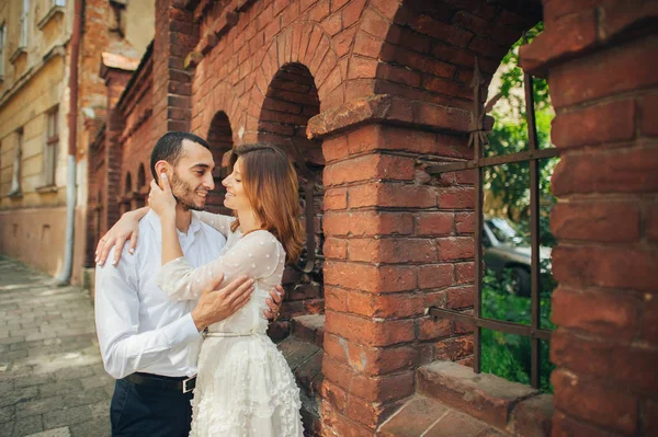 Par som kramas nära gammal byggnad — Stockfoto