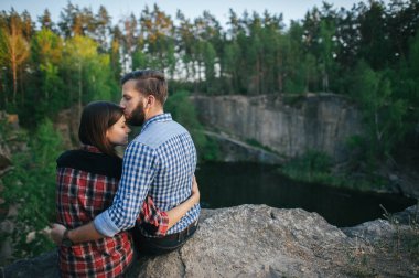 Kayanın üzerinde oturan Romantik Çift