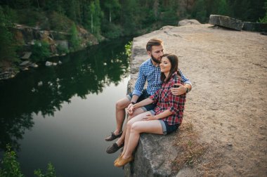 Kayanın üzerinde oturan Romantik Çift