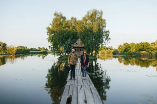 Pár stojící na dřevěný most od řeky — Stock fotografie