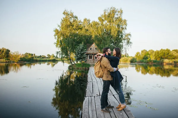 Пара, стоящая на деревянном мосту реки — стоковое фото