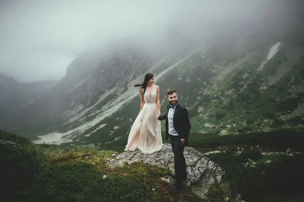 Uçurumun kenarında oturan yeni evliler — Stok fotoğraf