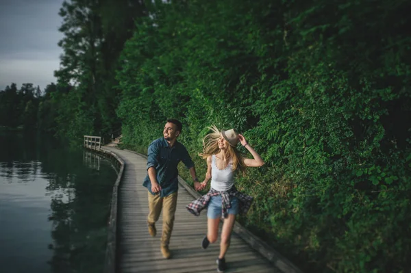 Casal correndo ao longo do cais de madeira — Fotografia de Stock
