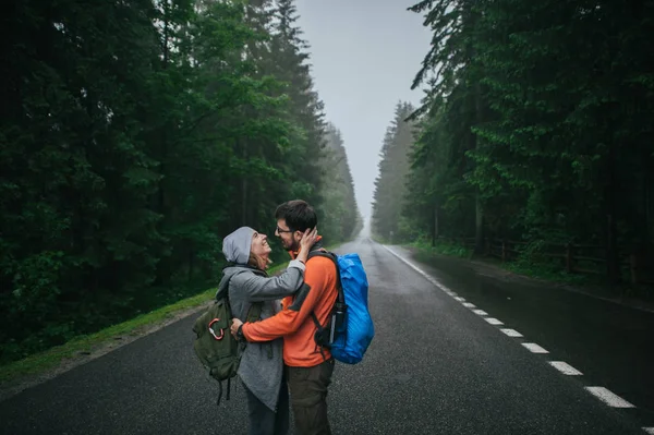 Pareja de viajeros abrazándose en el camino — Foto de Stock