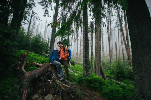 Pareja de viajeros abrazándose en el bosque — Foto de Stock