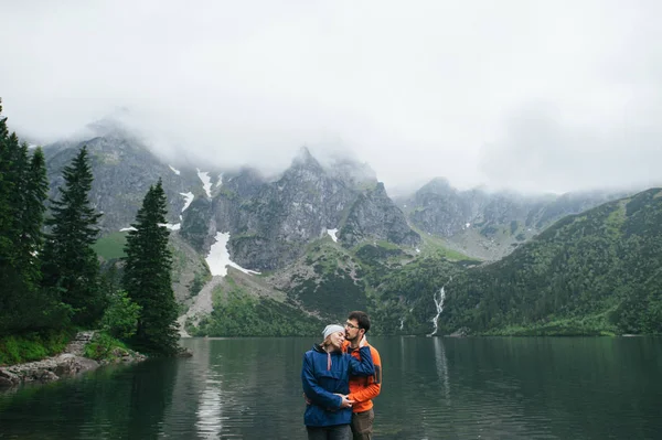 Traveler couple standing on rock near lake — Stock Photo, Image