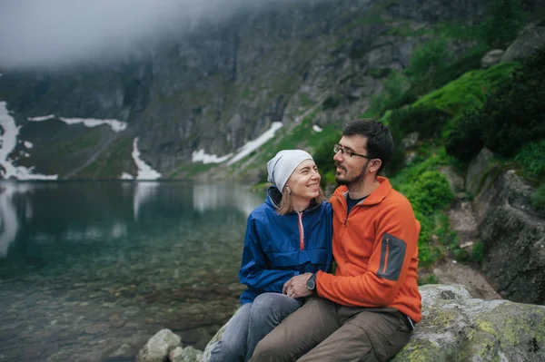 Rock lake yakınlarında oturan Gezgin Çift — Stok fotoğraf