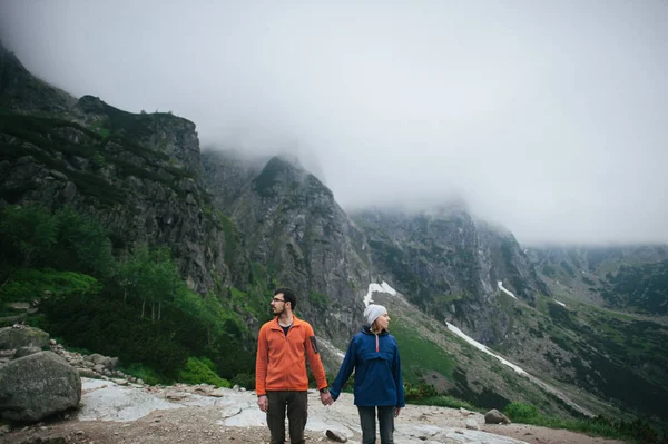 Couple de voyageurs marchant dans les montagnes — Photo