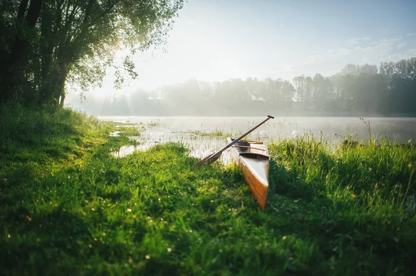 Каноэ с веслом на берегу озера — стоковое фото