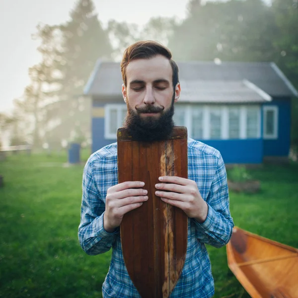 Knappe man met houten kano peddel — Stockfoto