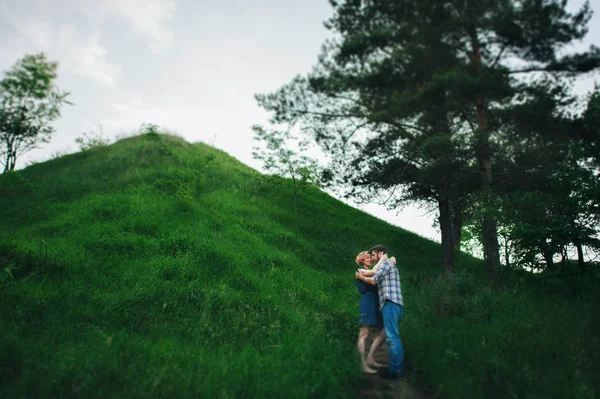 Casal de pé na colina verde — Fotografia de Stock