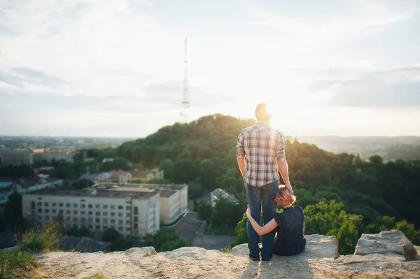 Couple sitting on edge of precipice — Stock Photo, Image