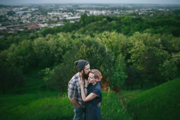 Пара обіймається на зеленому пагорбі — стокове фото