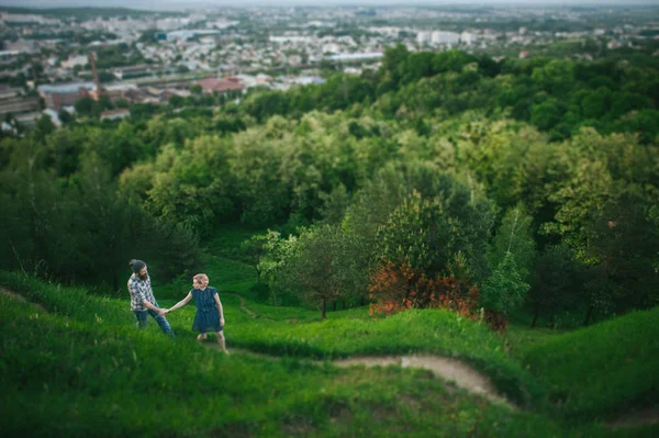 Casal andando na colina verde — Fotografia de Stock