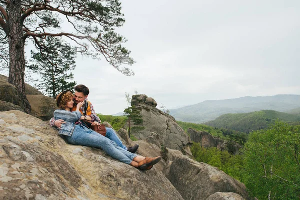 Viajero pareja sentado en el borde de la montaña — Foto de Stock