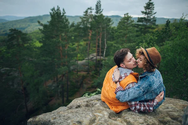 Viajero pareja sentado en el borde de la montaña — Foto de Stock