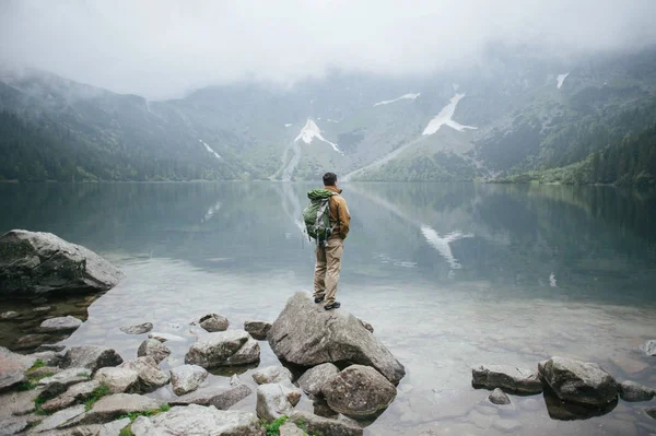 Adventure man hiking wilderness mountain with backpack Royalty Free Stock Photos