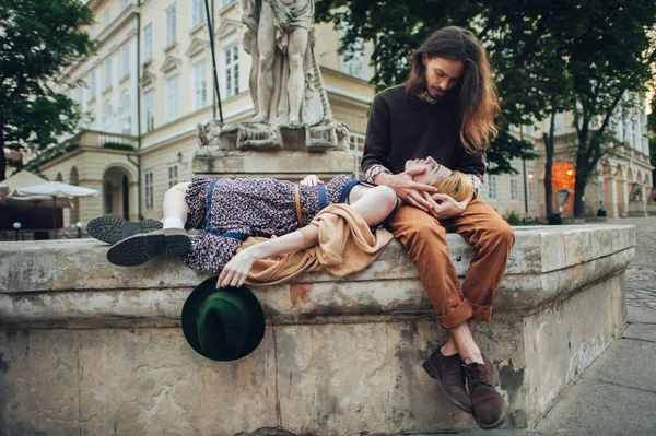 Couple on fountain edge in old town Royalty Free Stock Images