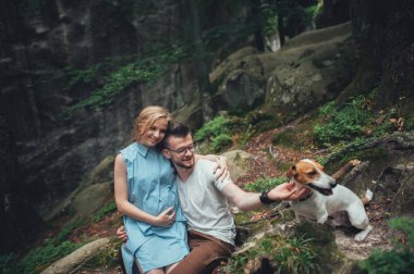 Çift kayanın üzerinde oturan ve köpek sevişme