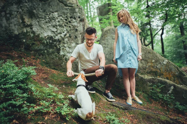Casal brincando com cão em montanhas — Fotografia de Stock