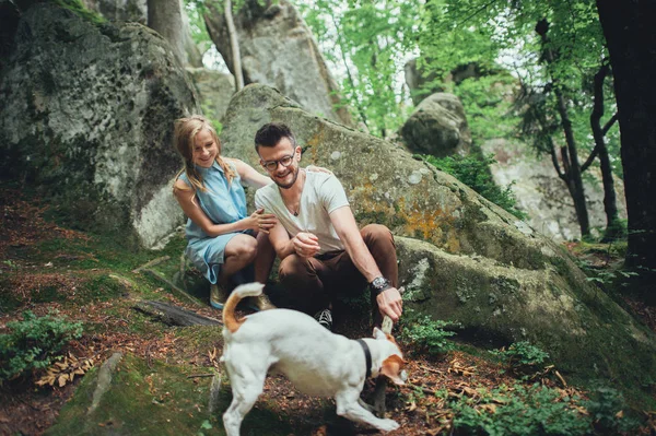 Casal brincando com cão em montanhas — Fotografia de Stock