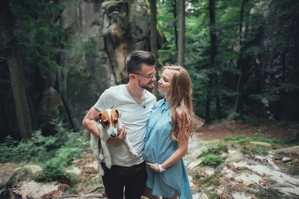 Casal em pé na colina da floresta com o cão — Fotografia de Stock