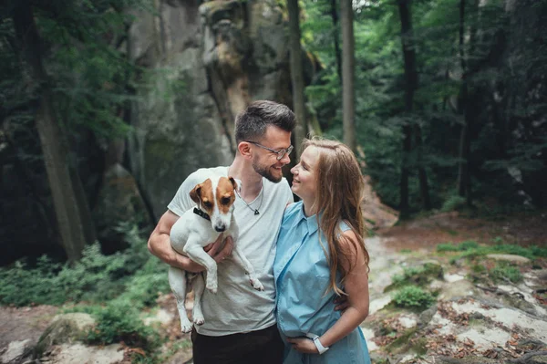 Couple standing in forest hill with dog — Stock Photo, Image