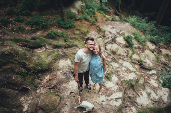 Par poserar med hunden i skogen hill — Stockfoto