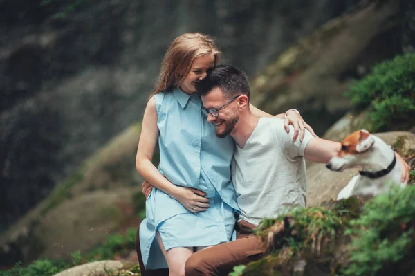 Çift kayanın üzerinde oturan ve köpek sevişme