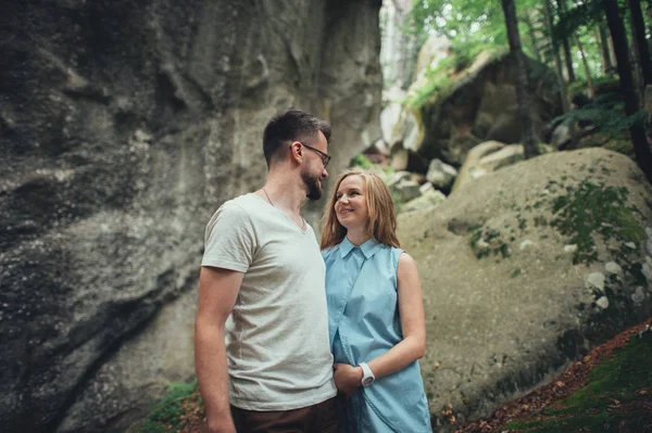 Жінка і чоловік обіймаються в каньйоні з мохом на каменях — стокове фото