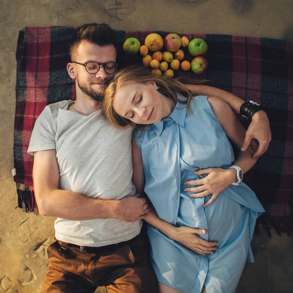 Giovane coppia sdraiata su una coperta da picnic — Foto Stock