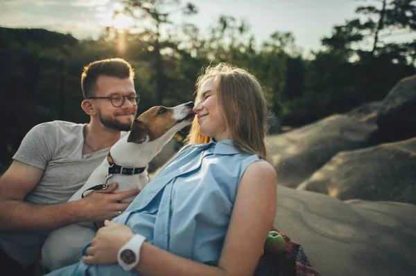 Piknik battaniyesi ile köpek oturan Çift