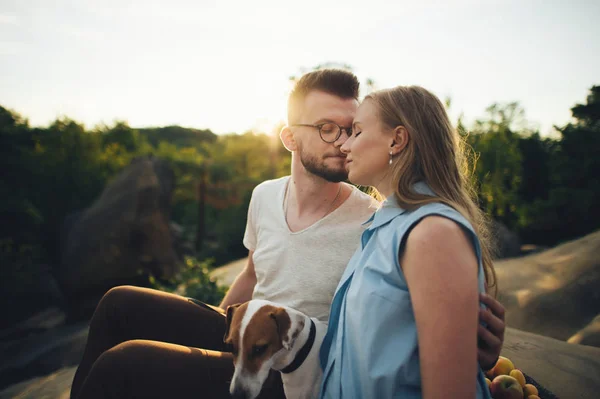 Pareja sentada en una manta de picnic con perro — Foto de Stock